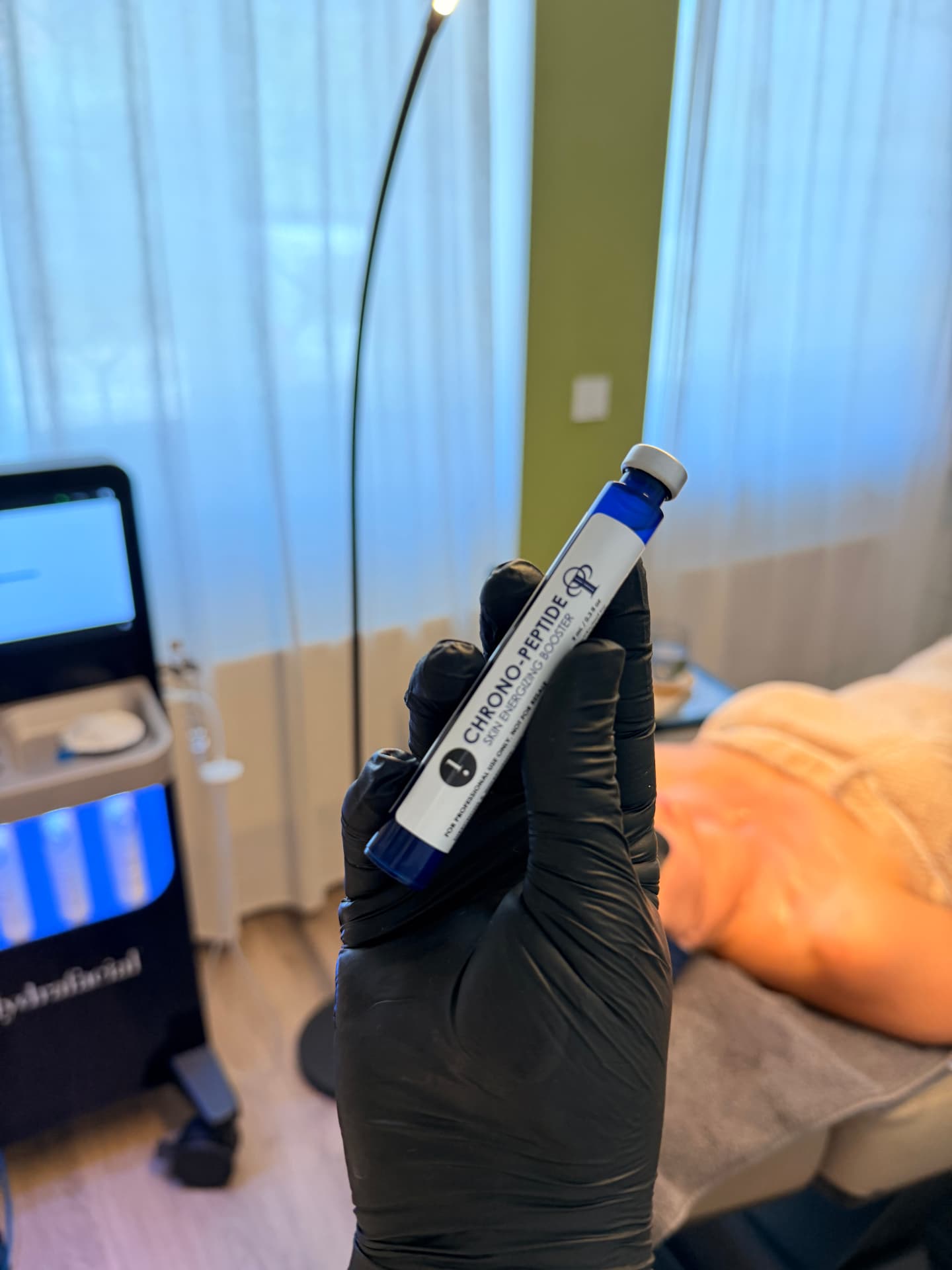 Booster-Ampulle vor dem HydraFacial-Gerät im Behandlungsraum